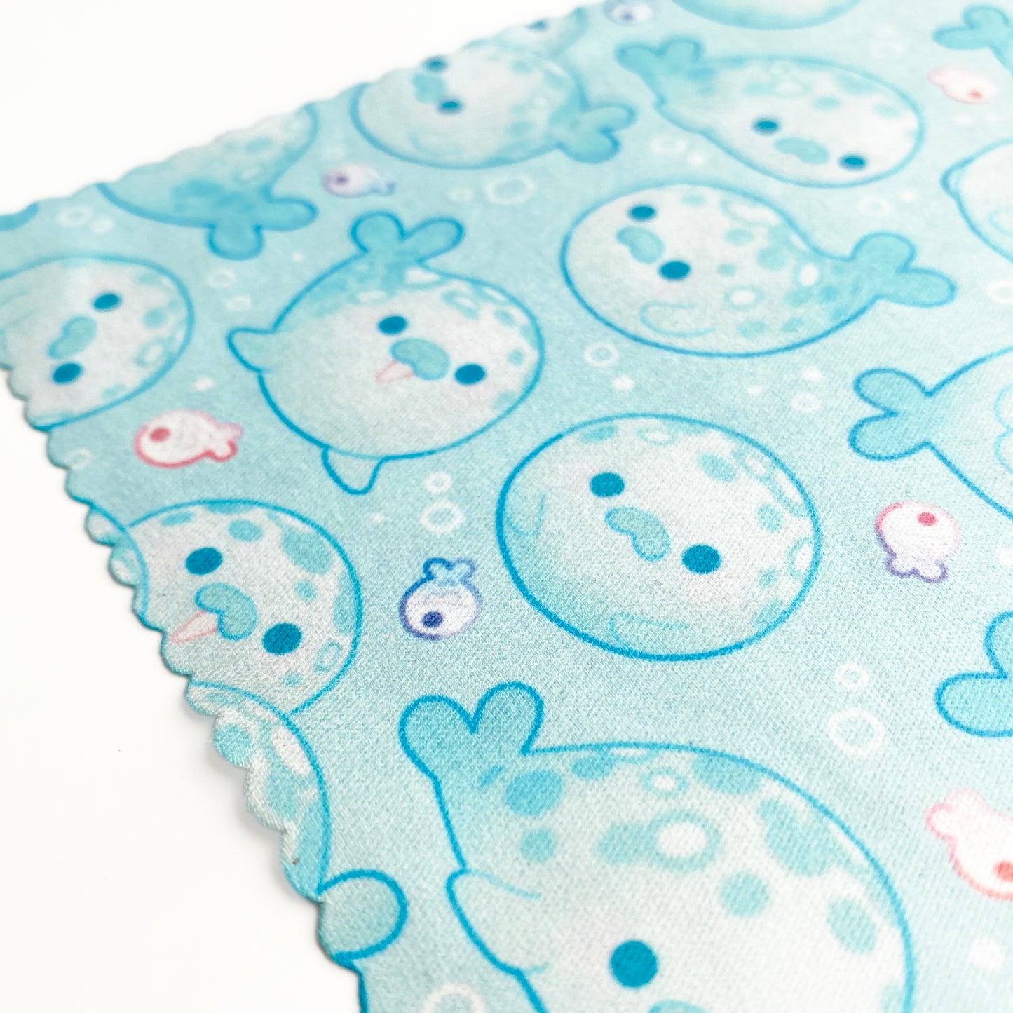 a close-up of the pattern of round kawaii seals surrounded by water bubbles and little fishies. They're happy and smiling!