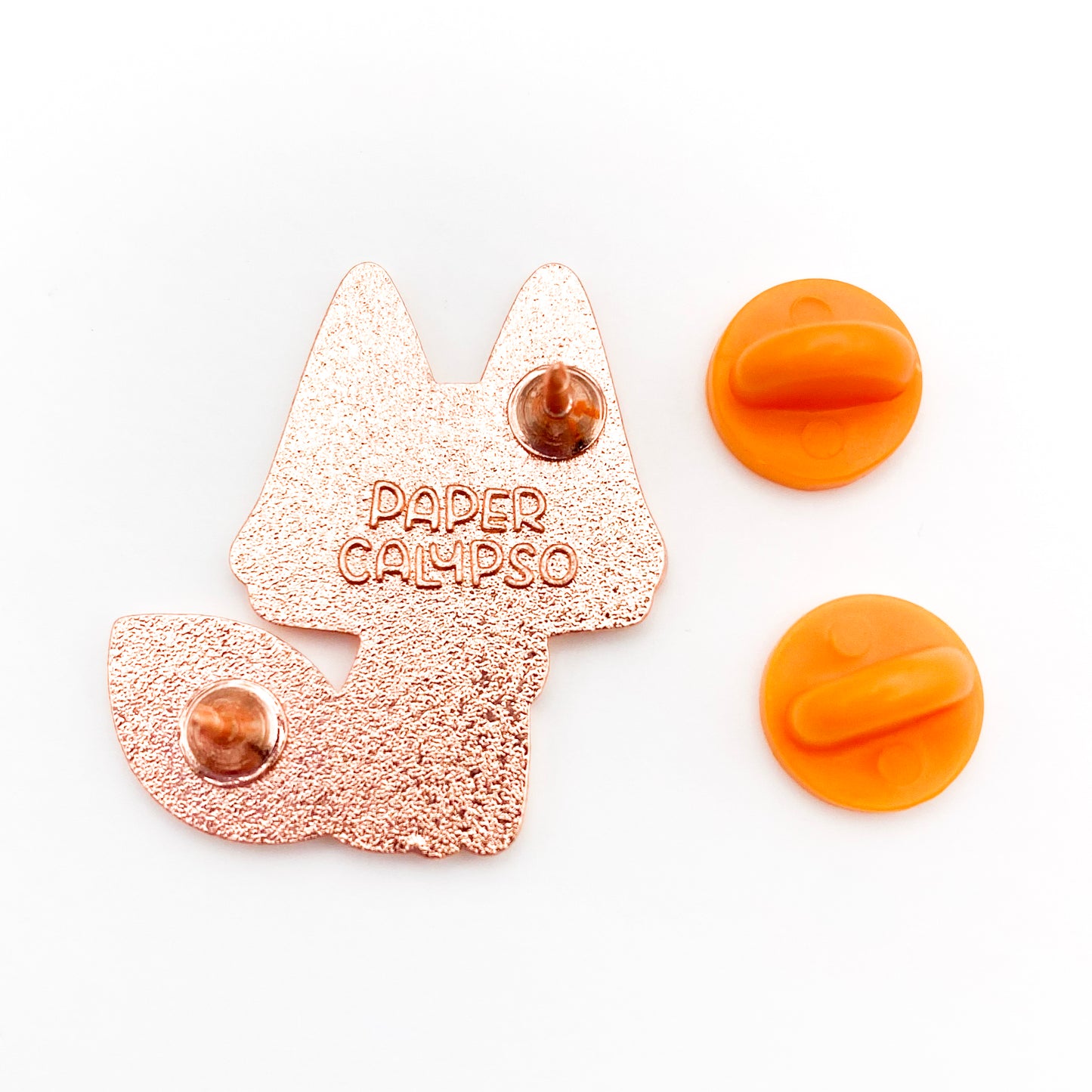 there are two pins on the back for extra security! This way you won't lose your pin if you put it on your clothes or bag. It comes with orange colored rubber clasps. The back of the pin has a stamp with my watermark and reads "Paper Calypso"