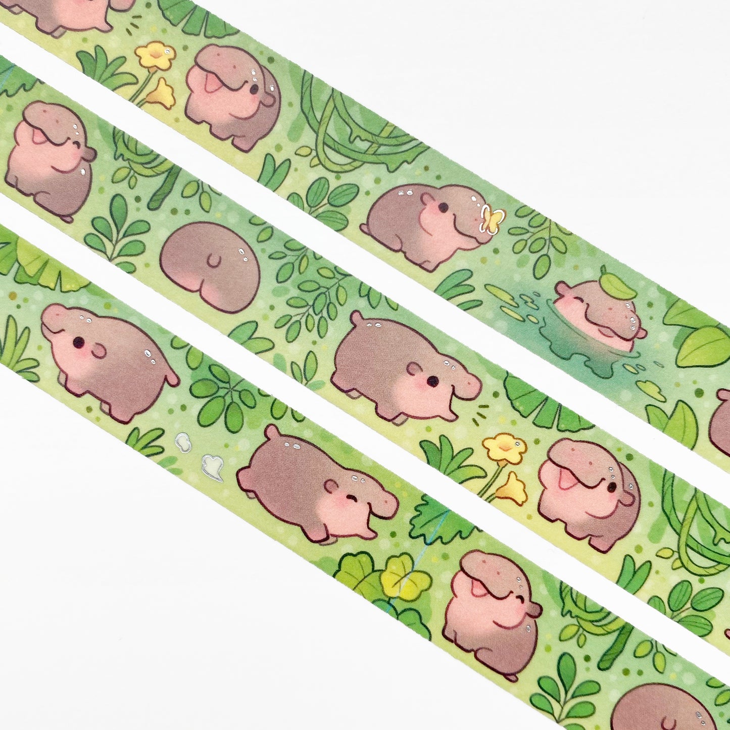 A close-up of the washi tape. The hippos are surrounded by green jungle plants and yellow butterflies and fflowers. One is even bathing in a little pond.