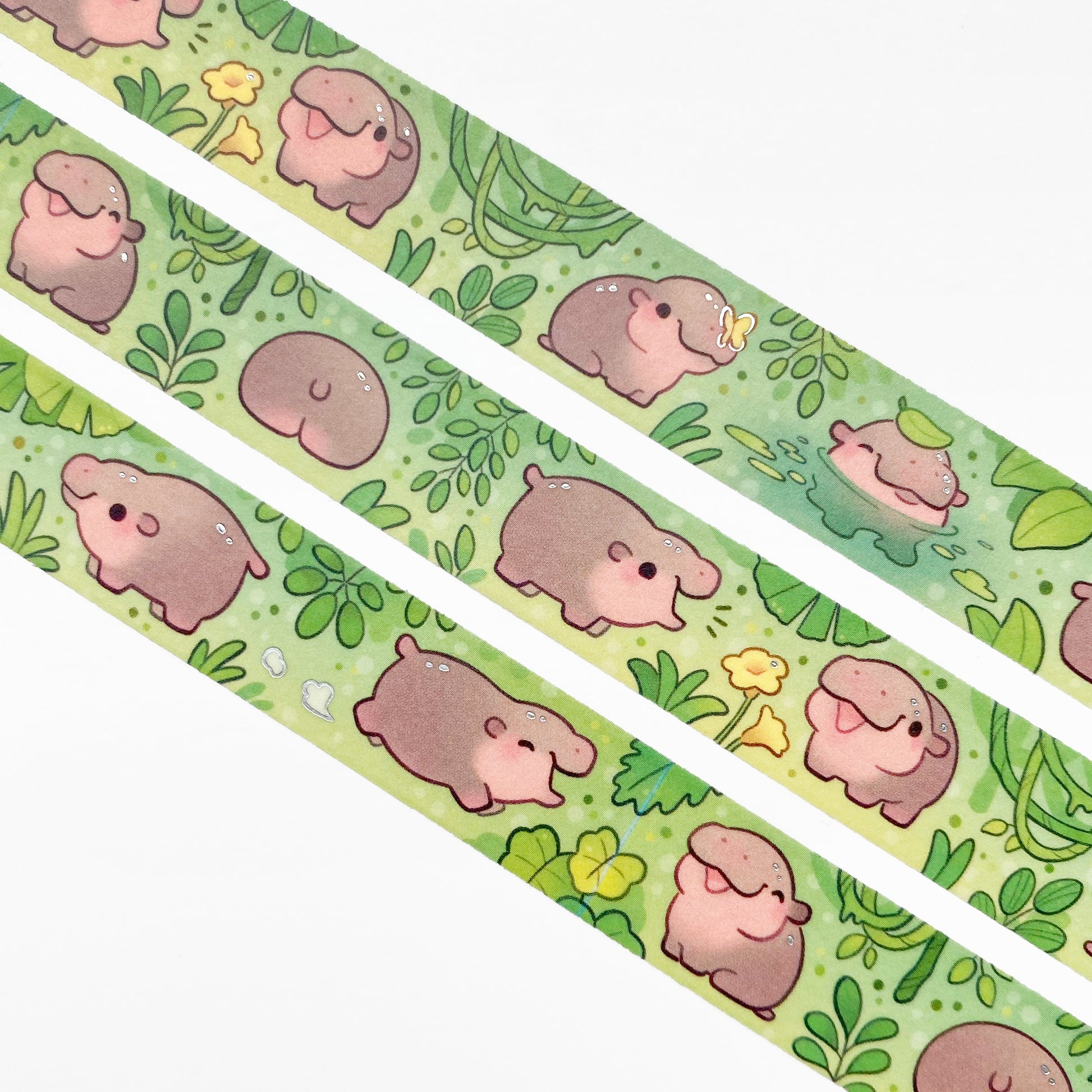 A close-up of the washi tape. The hippos are surrounded by green jungle plants and yellow butterflies and fflowers. One is even bathing in a little pond.