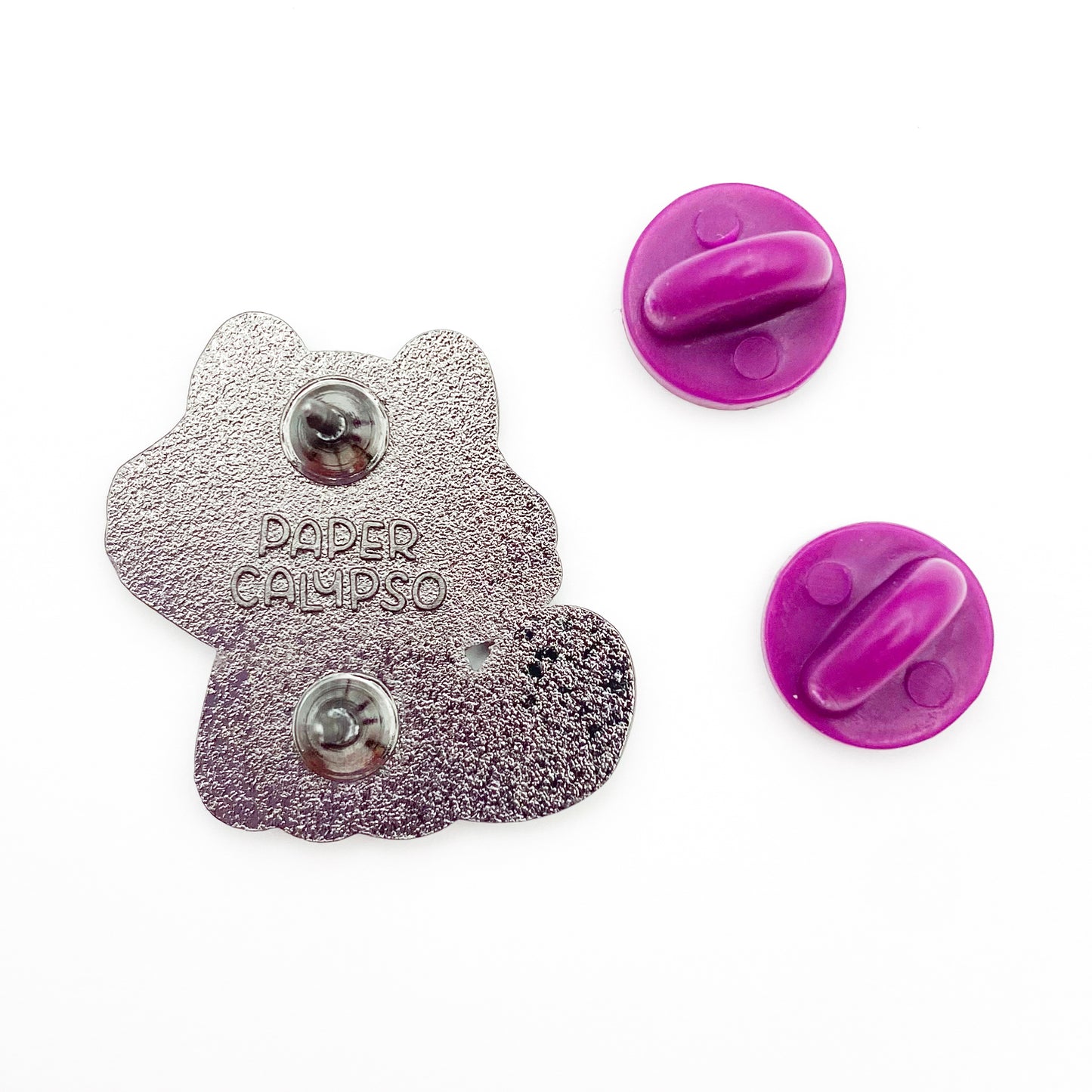 there are two pins on the back for extra security! This way you won't lose your pin if you put it on your clothes or bag. It comes with purple colored rubber clasps. The back of the pin has a stamp with my watermark and reads "Paper Calypso"