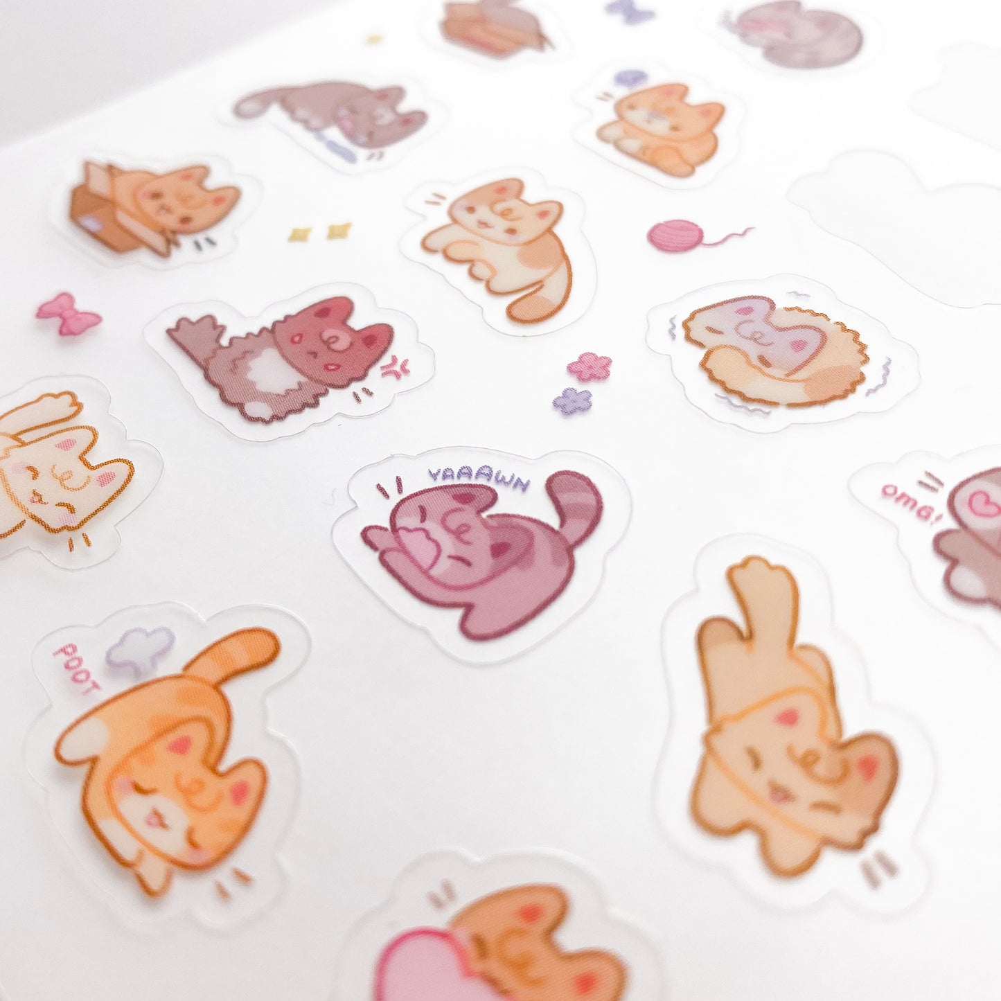 a close-up of the stickers to show the good print quality. In the middle is a cat stretching and yawning with the text "yaaawn" next to it. Below it is a cat farting with the text "poot" There is also one shaking in fear.
