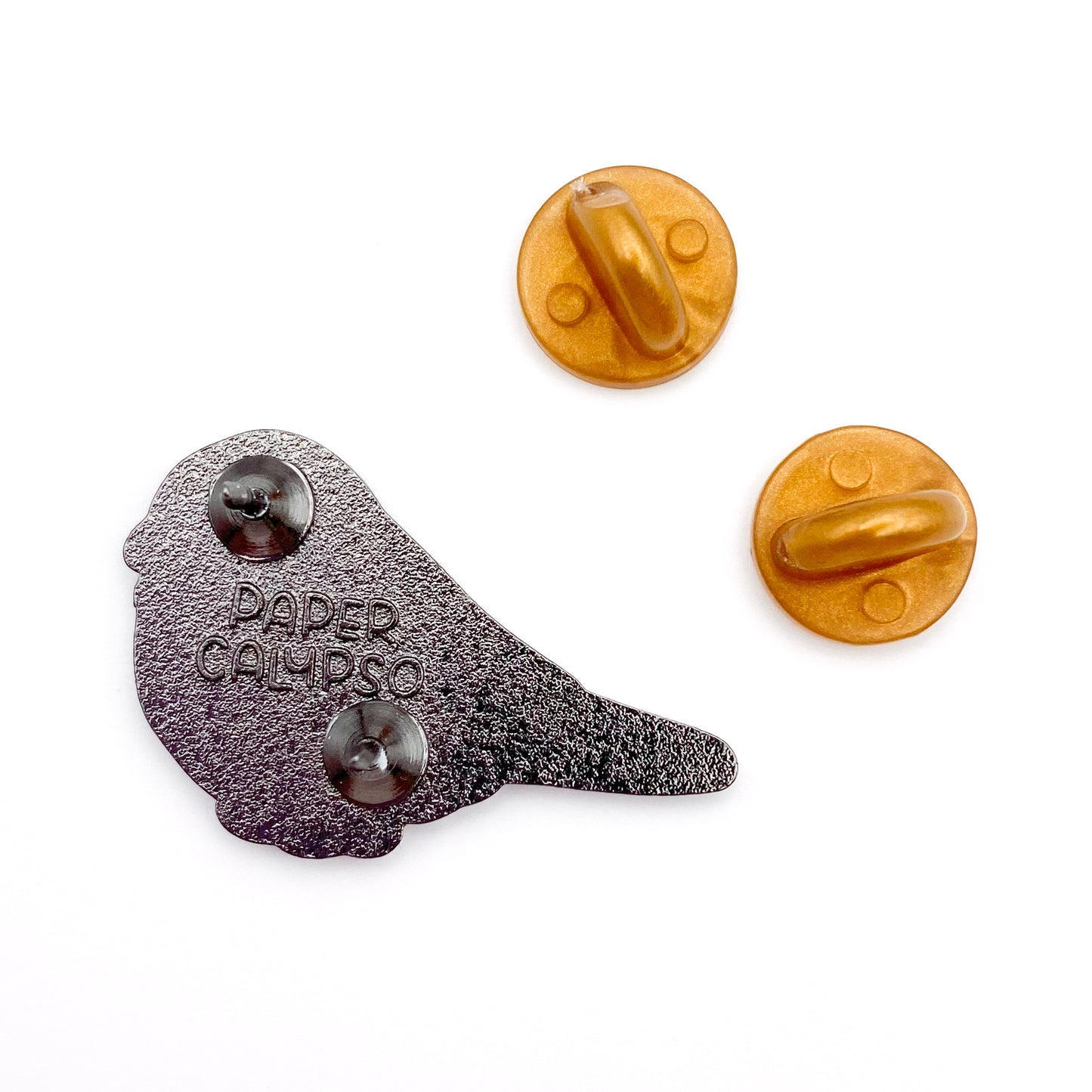 there are two pins on the back for extra security! This way you won't lose your pin if you put it on your clothes or bag. It comes with gold colored rubber clasps. The back of the pin has a stamp with my watermark and reads "Paper Calypso"