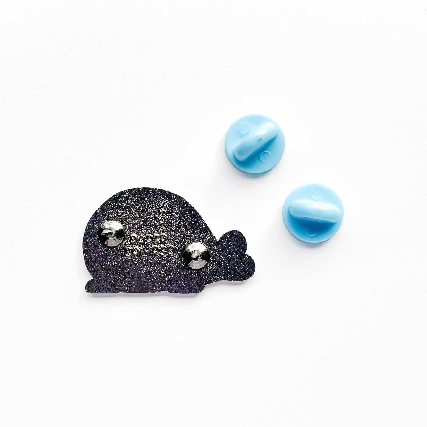 there are two pins on the back for extra security! This way you won't lose your pin if you put it on your clothes or bag. It comes with blue rubber clasps. The back of the pin has a stamp with my watermark and reads "Paper Calypso"