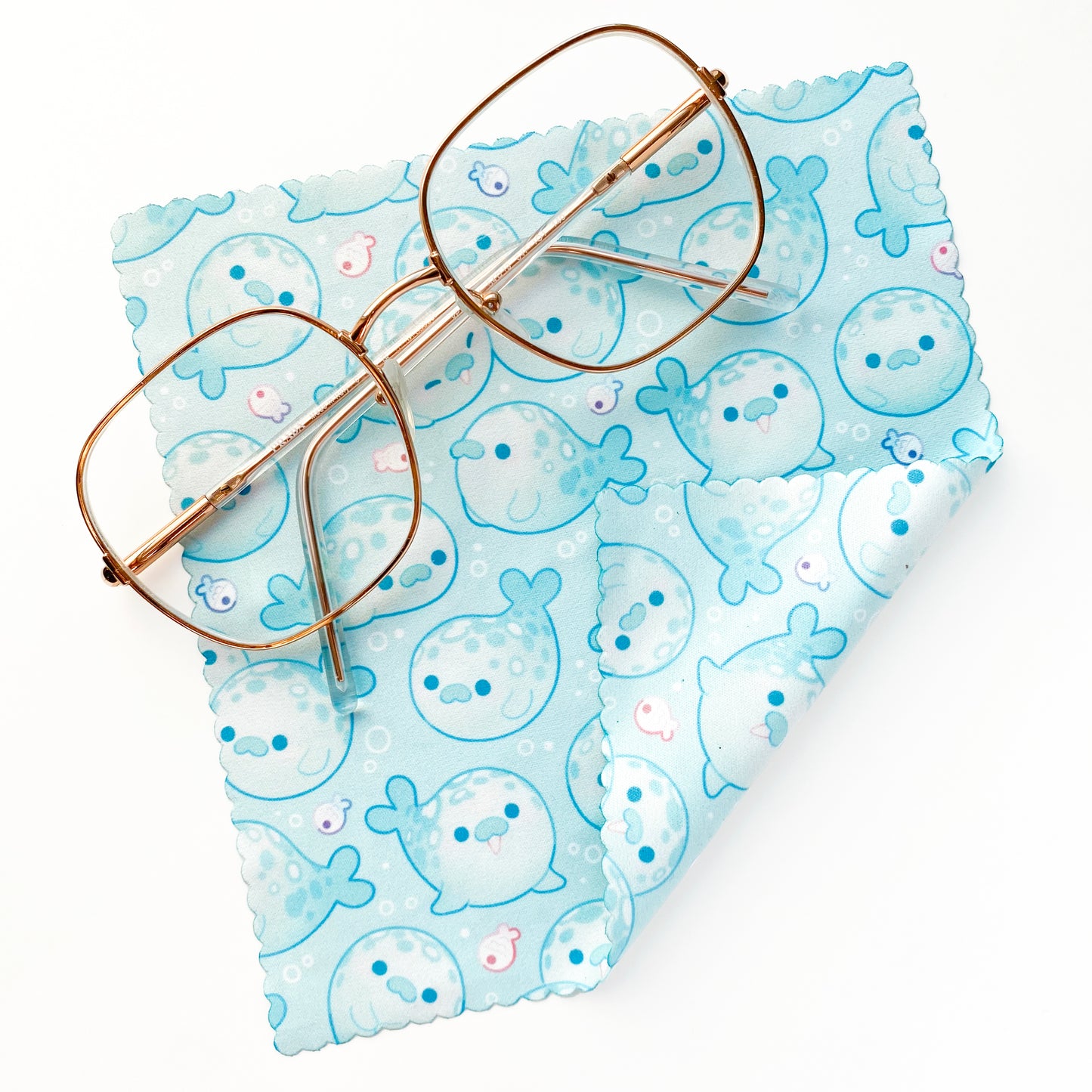 some pastel teal turqouise blue seals on a microfibre cloth to clean your sunglasses, glasses, reading glasses, camera lenses or screens! Cute, round, kawaii.