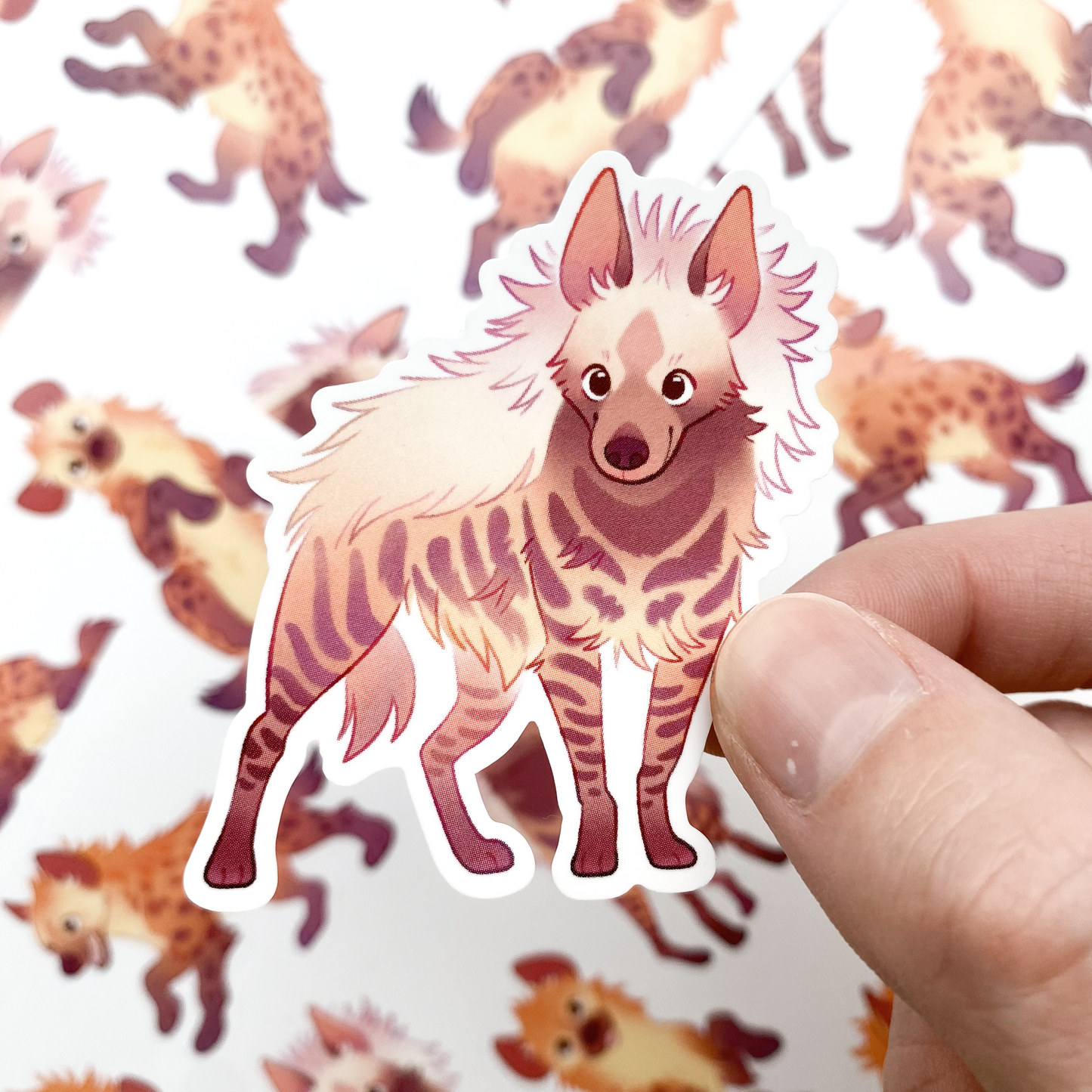 A sticker of a striped hyena posing elegantly and smiling sweetly at the camera. All the hyenas are smiling. If you like african wildlife these happy hyenas are for you!