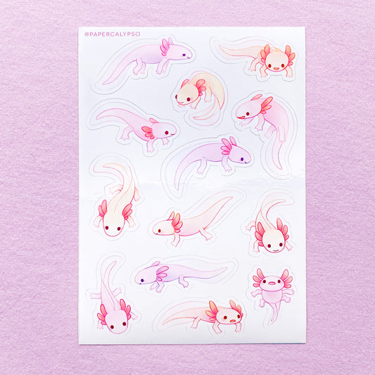 The axolotls are purple, pink and yellow pastel coloured, with little grabby fingers and thick tails. Their gills are stubby, round and cute. Most of them are smiling, while some look a bit stupid and clueless. The sticker sheet has thirteen unique stickers printed on white glossy thin vinyl. This makes them sturdy and waterproof, but not too thick to use in a journal.