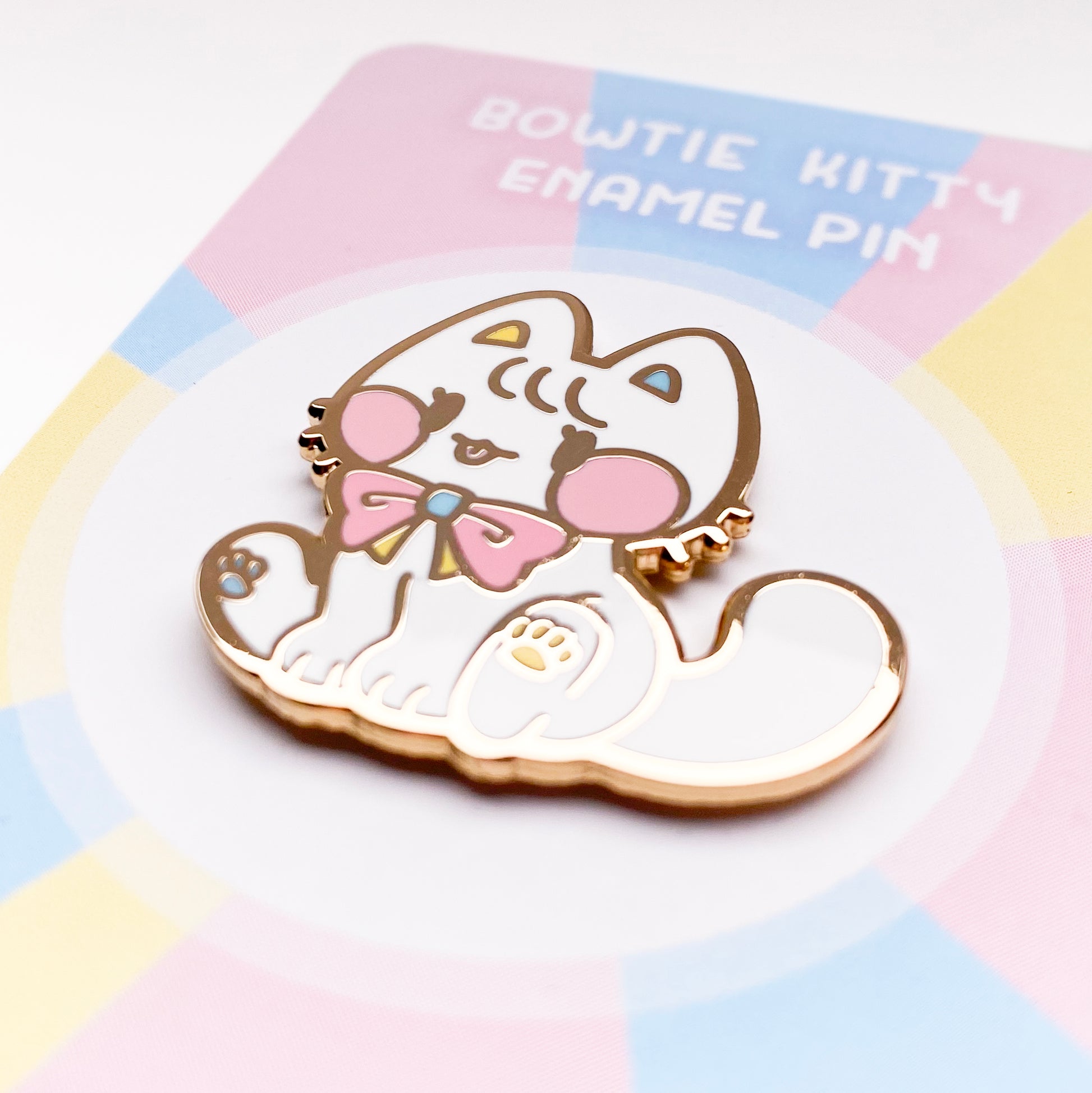 a close-up of the pin to better show the quality. The enamel is nice and smooth. The backing card reads "Bowtie Kitty Enamel Pin"