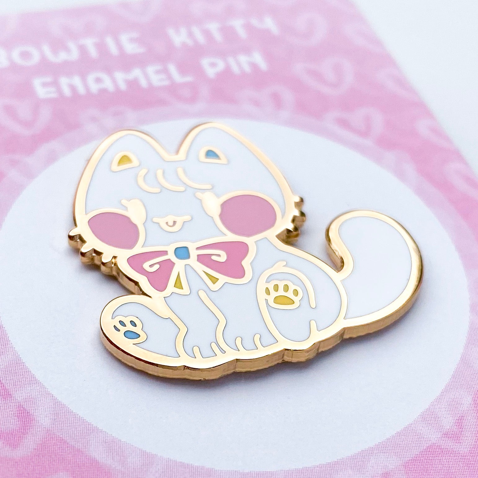 a close-up of the pin to better show the quality. The enamel is nice and smooth. The backing card is a bunch of pink hearts. To keep it scratch-free, the pins are packaged in cellophane baggies.