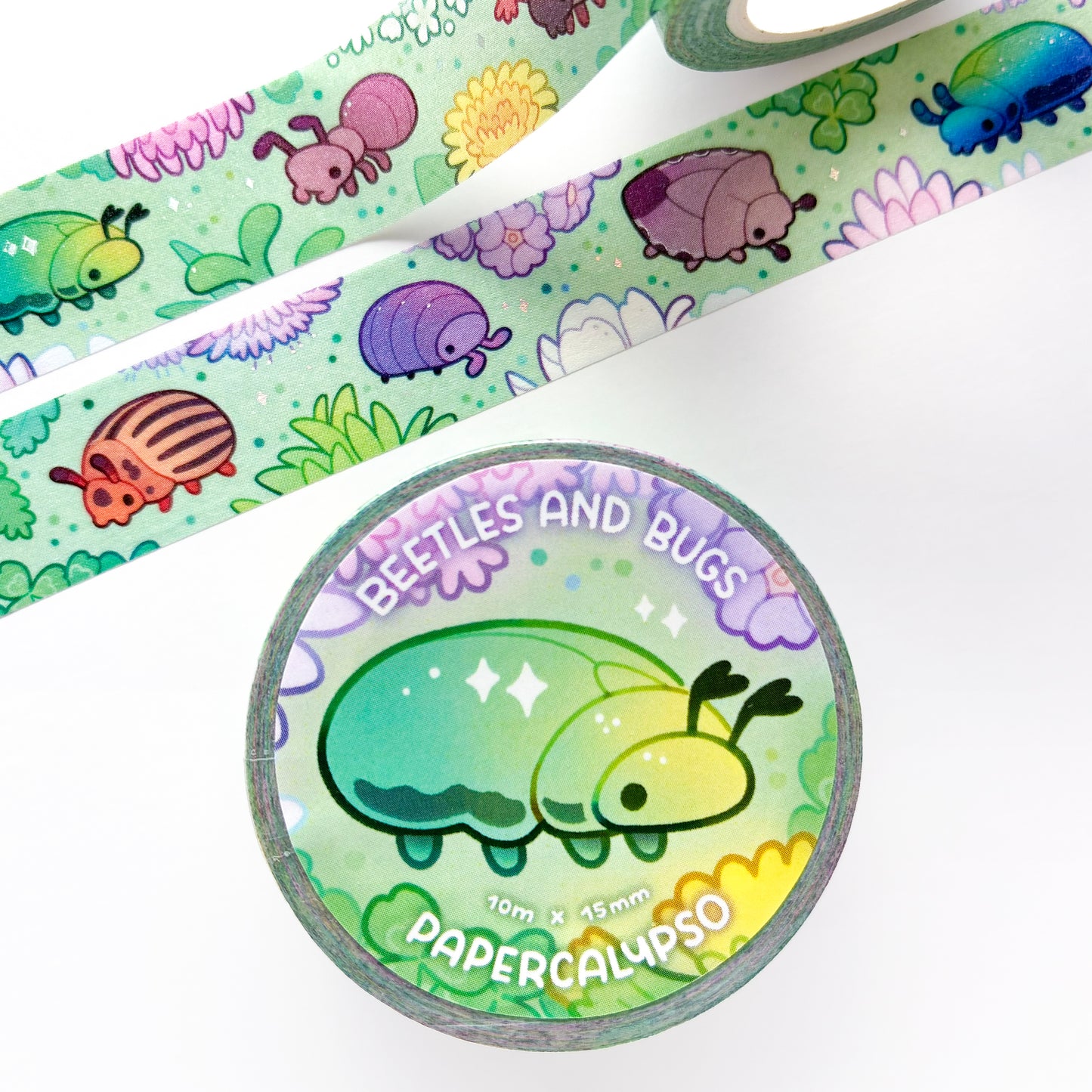 the roll of washi tape is packaged with shrink wrap plastic and a round sticker on one side. On it is a rose beetle surrounded by flowers. It reads "Beetles and Bugs, 10 metres by 15 milimetres, by Papercalypso"