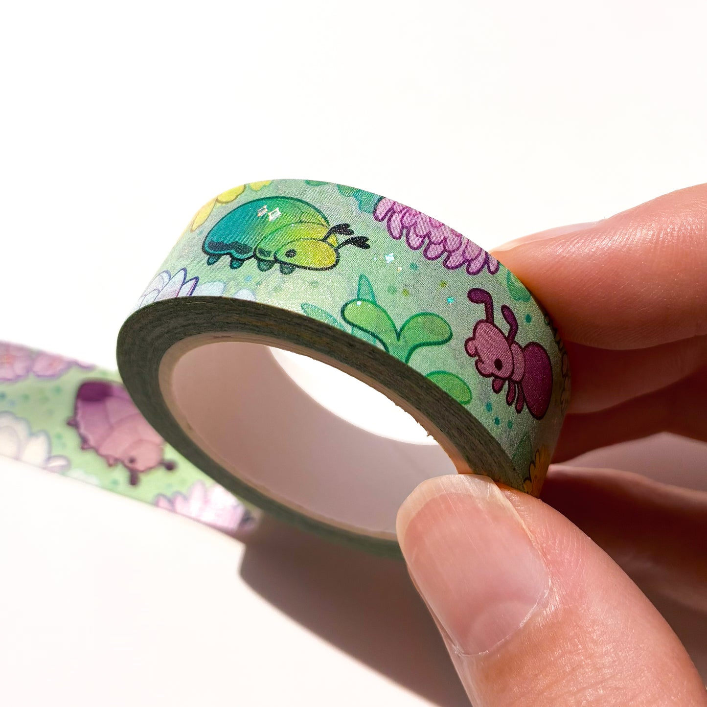 A different angle showing the holographic silver foil reflecting in the light. The foil is used to highlight some shiny parts of the bugs' exoskeletons. 
