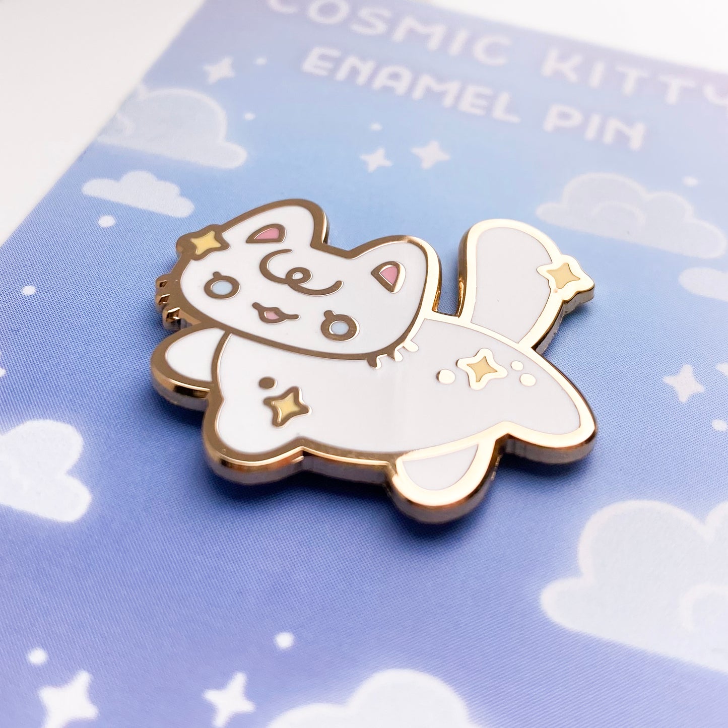 a close-up of the pin to better show the quality. The enamel is nice and smooth. The backing card is a magical pastel blue sky with stars and clouds. 