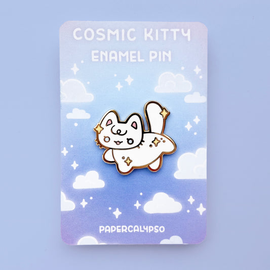 A gold hard enamel pin of a white kitty cat with stars in its fur. The stars are yellow and it has pretty light blue eyes. It's striking a cute pose by lifting one hind leg and one front leg and smiling. 