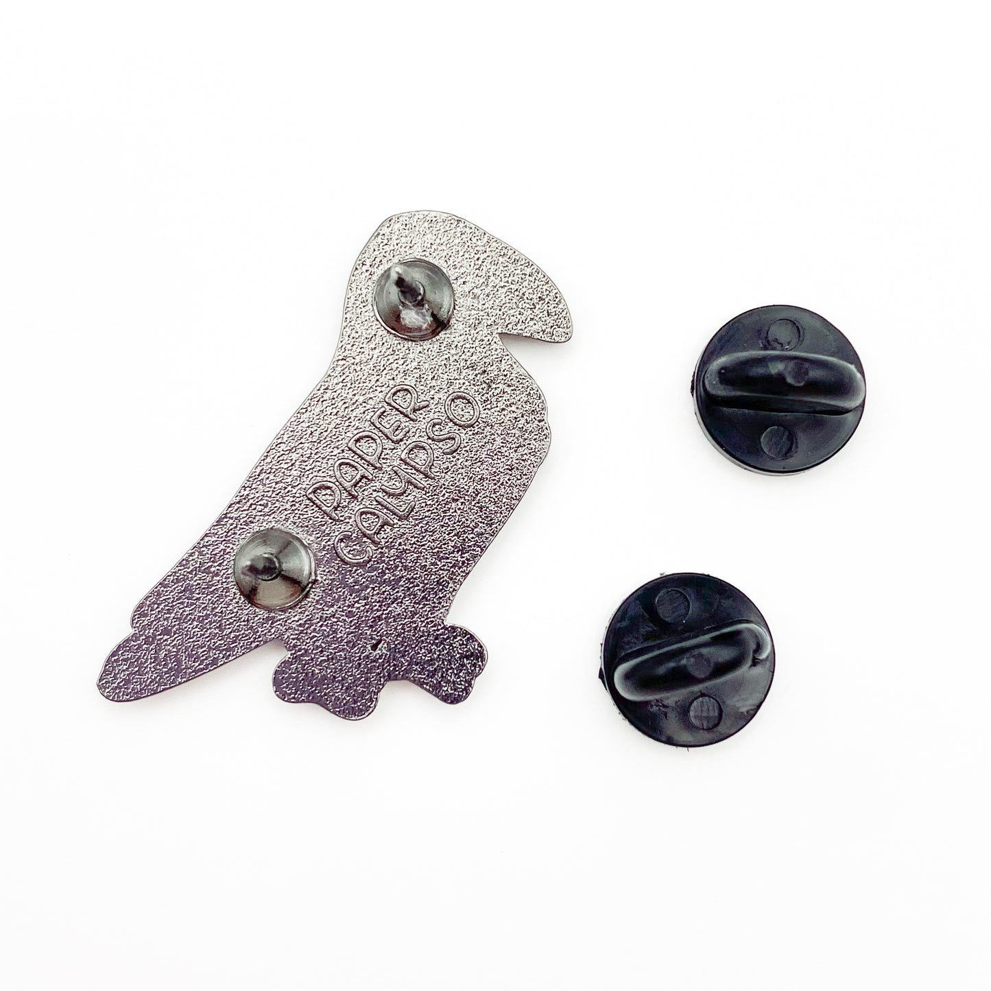 there are two pins on the back for extra security! This way you won't lose your pin if you put it on your clothes or bag. It comes with black rubber clasps. The back of the pin has a stamp with my watermark and reads "Paper Calypso"