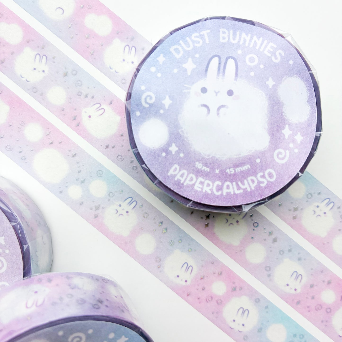 kawaii dust bunny themed washi tape featuring round, white cartoon rabbits on a pastel pink background. The bunnies are calmly floating around and enjoying their existence as little balls of dust.