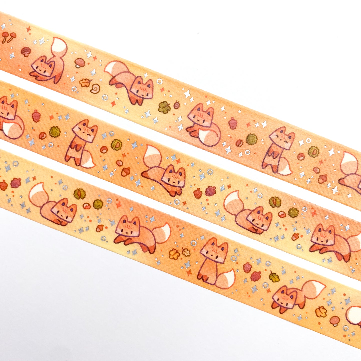 A close-up of the washi tape. The foxes are surrounded by things you can find on the forest floor during fall, like mushrooms, acorns, colourful leaves, snails and pine cones.