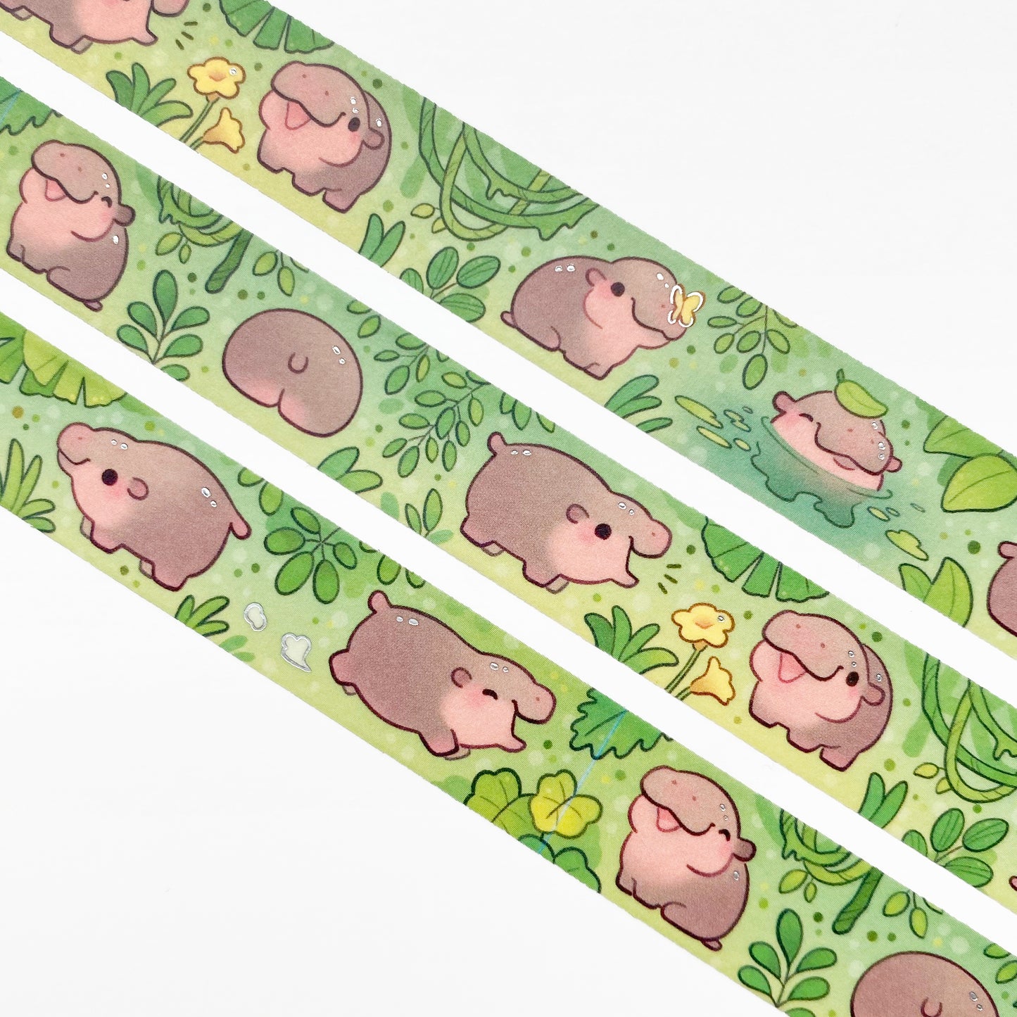 A close-up of the washi tape. The hippos are surrounded by green jungle plants and yellow butterflies and fflowers. One is even bathing in a little pond. 