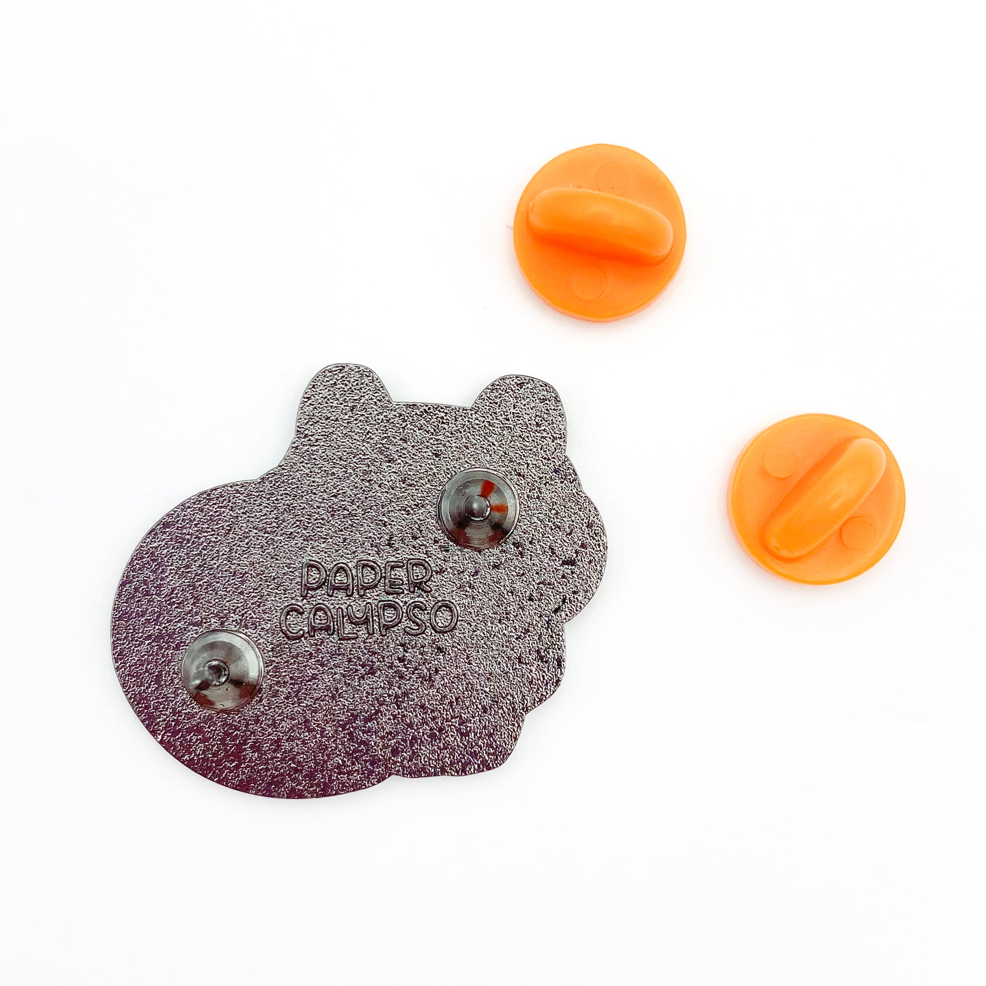 there are two pins on the back for extra security! This way you won't lose your pin if you put it on your clothes or bag. It comes with orange colored rubber clasps. The back of the pin has a stamp with my watermark and reads "Paper Calypso"