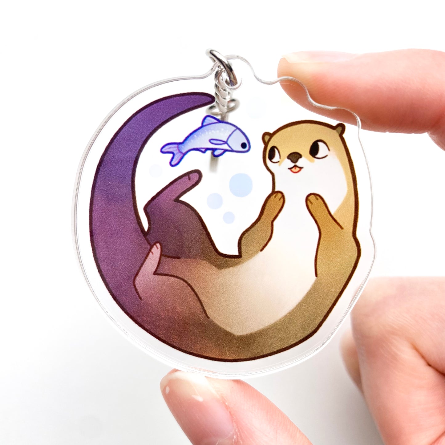 a picture of me holding the keychain, so you get a better feeling for its size. The fish and the otter look like they're having fun!