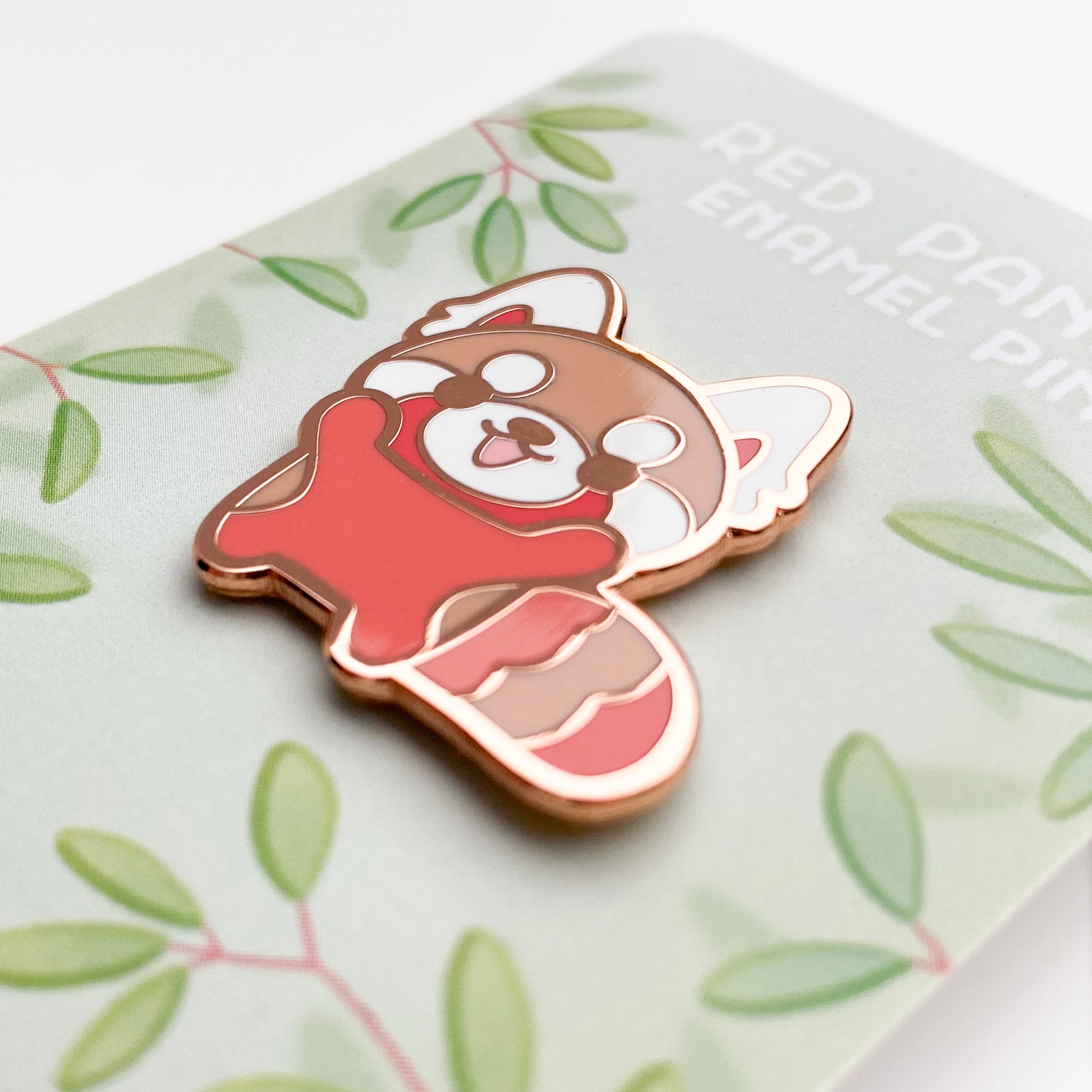 A close-up of the pin so you can see the details. The pin backing is a bamboo forest with the title "Red Panda Enamel Pin".