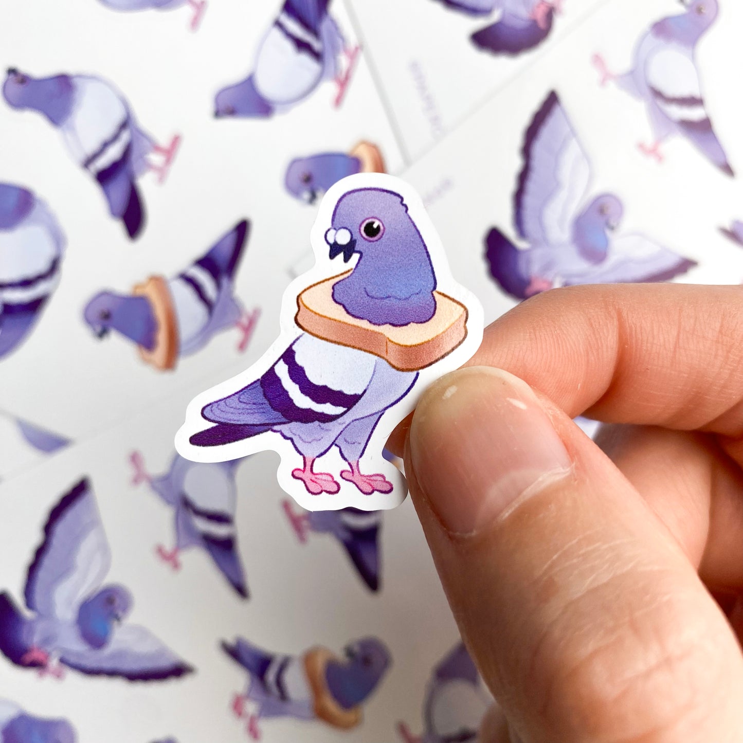 A sticker of a pigeon posing proudly with a piece of bread around its neck. The poses are funny and silly, two are wearing white toast while another has a pink bowtie, two others are grooming themselves. If you like urban wildlife these humorous birds are for you!