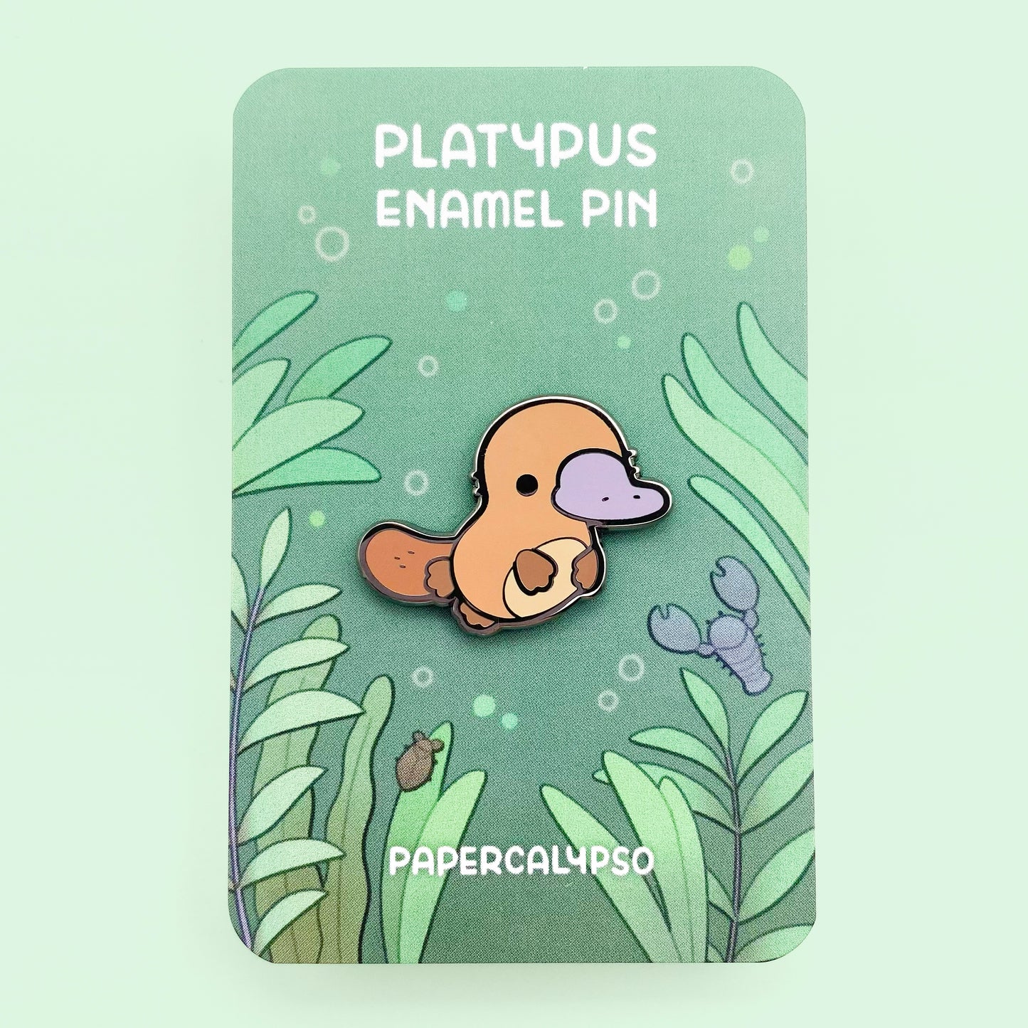 A black nickel plated hard enamel pin of a kawaii cute chibi brown platypus.