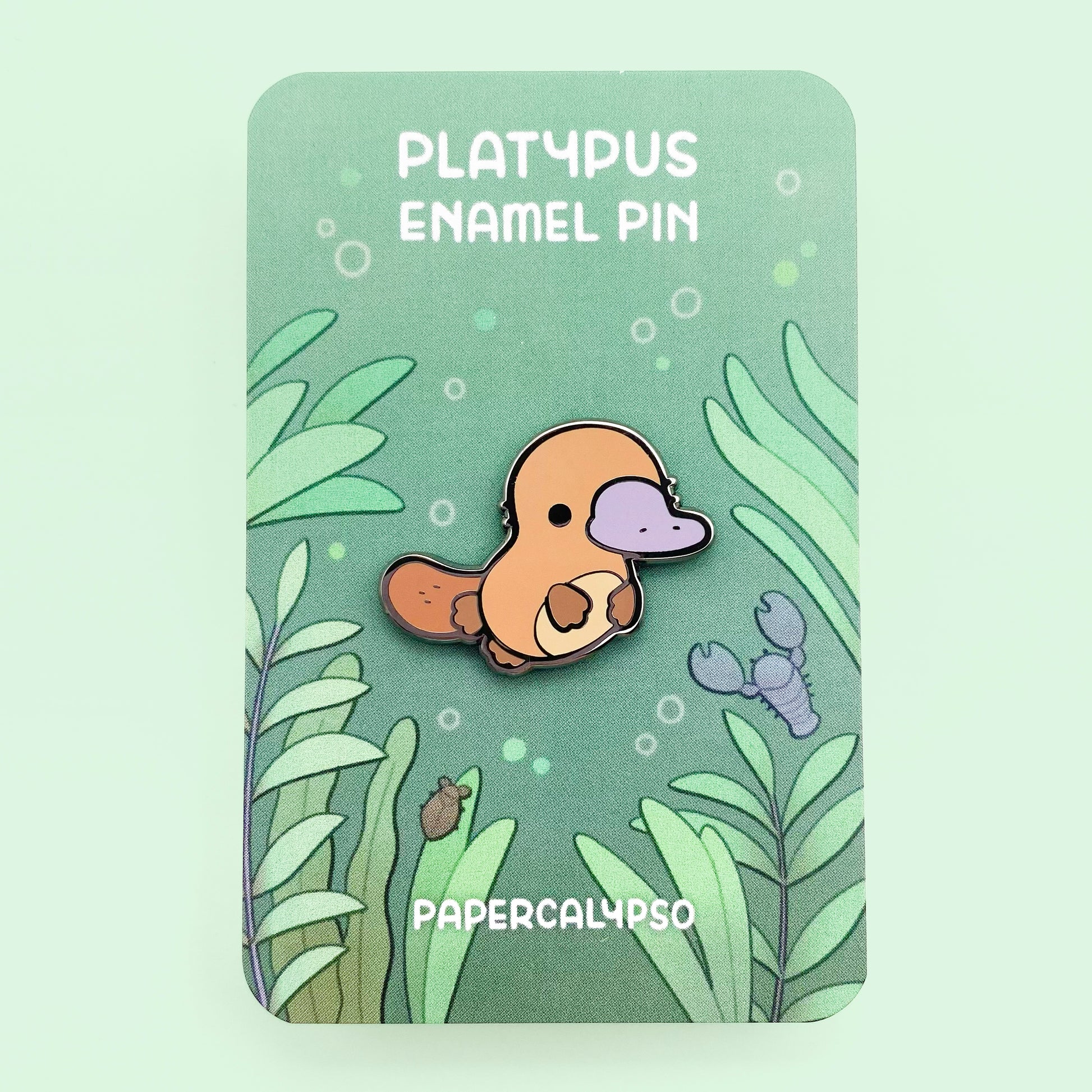 A black nickel plated hard enamel pin of a kawaii cute chibi brown platypus.
