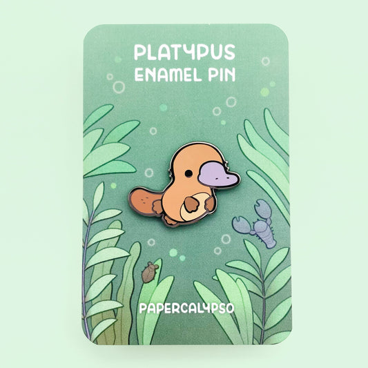 A black nickel plated hard enamel pin of a kawaii cute chibi brown platypus.