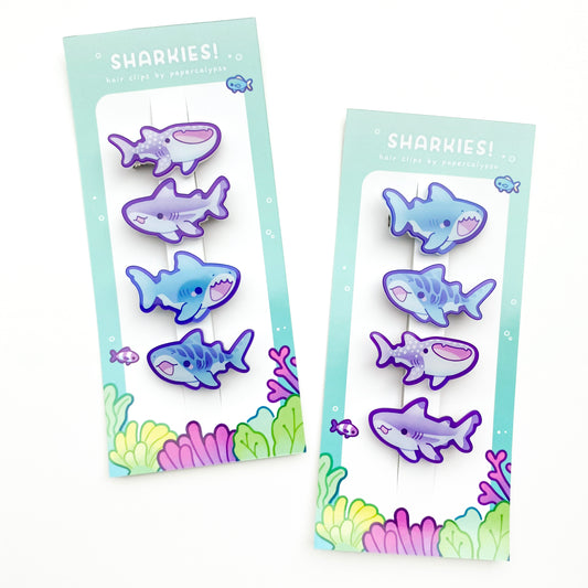 four cute shark hairclips a tiger shark, a great white, a whale shark and a black-tipped reef shark! One purple and one blue set. 