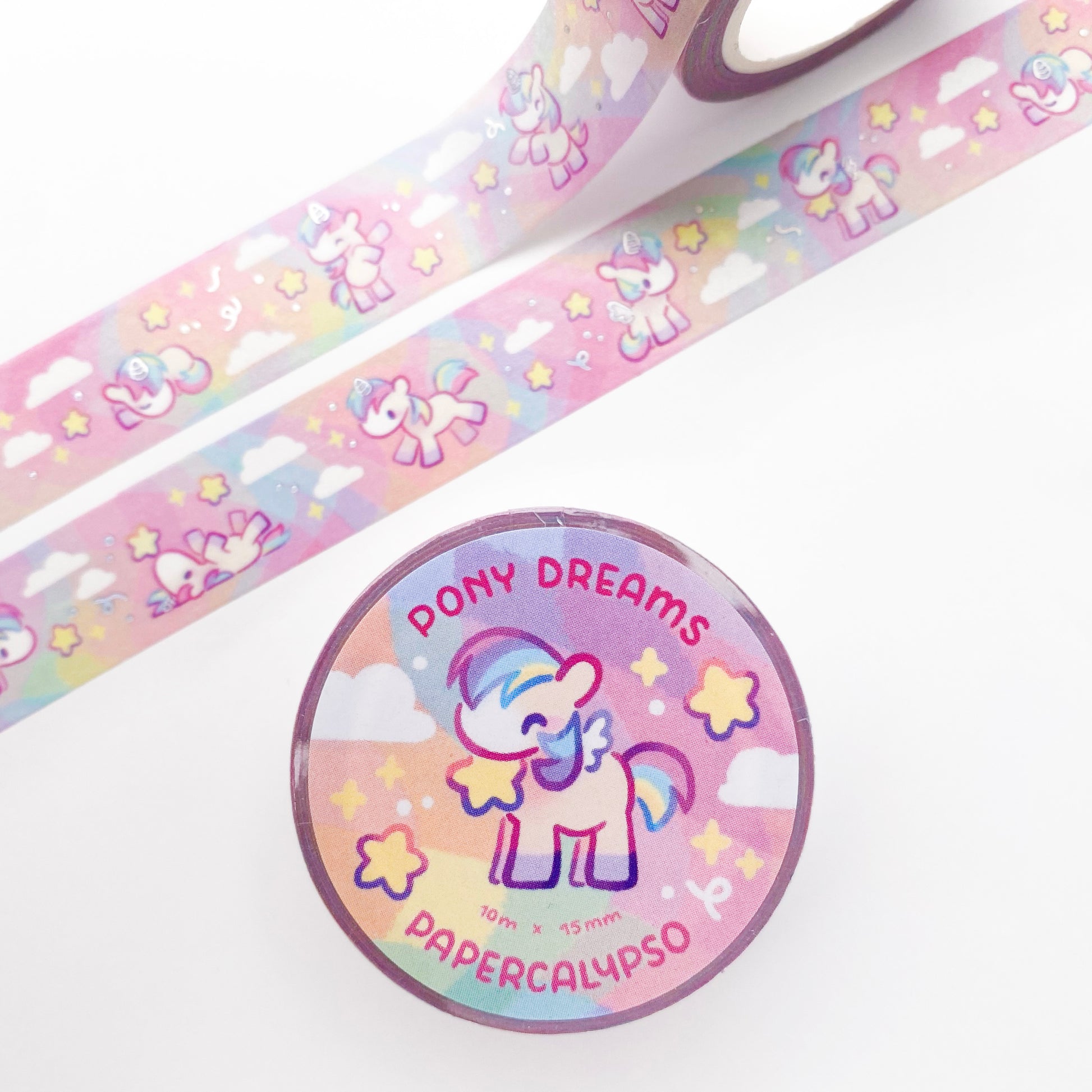 The roll of washi tape is packaged with shrink wrap plastic and a round sticker on one side. On it is an adorable pegasus pony with a star in it's mouth. It reads "Pony Dreams, 10 metres by 15 milimetres, by Papercalypso" 