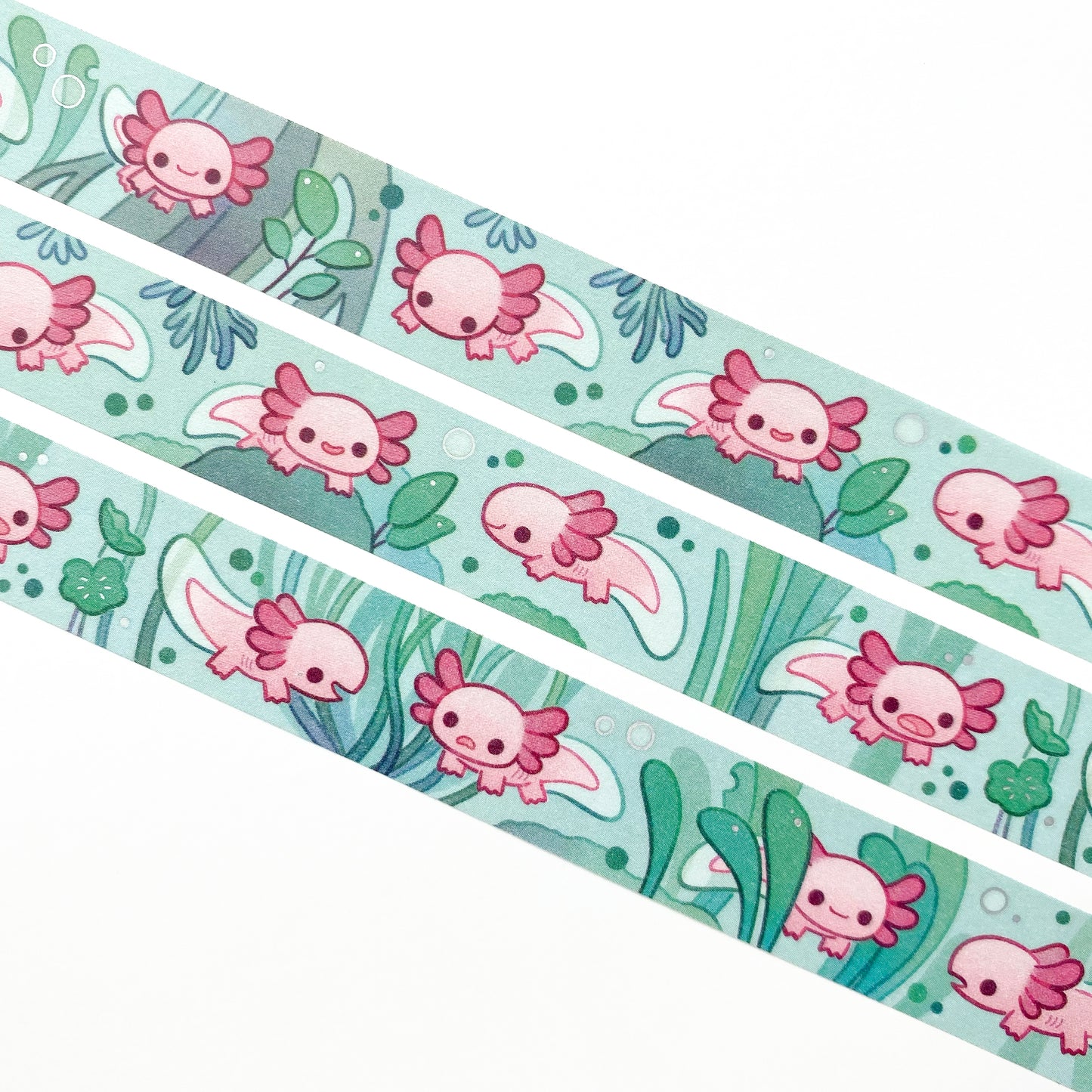 A close-up of the washi tape. The axolotls are swimming around among the roots, leaves, algae and other plants. 