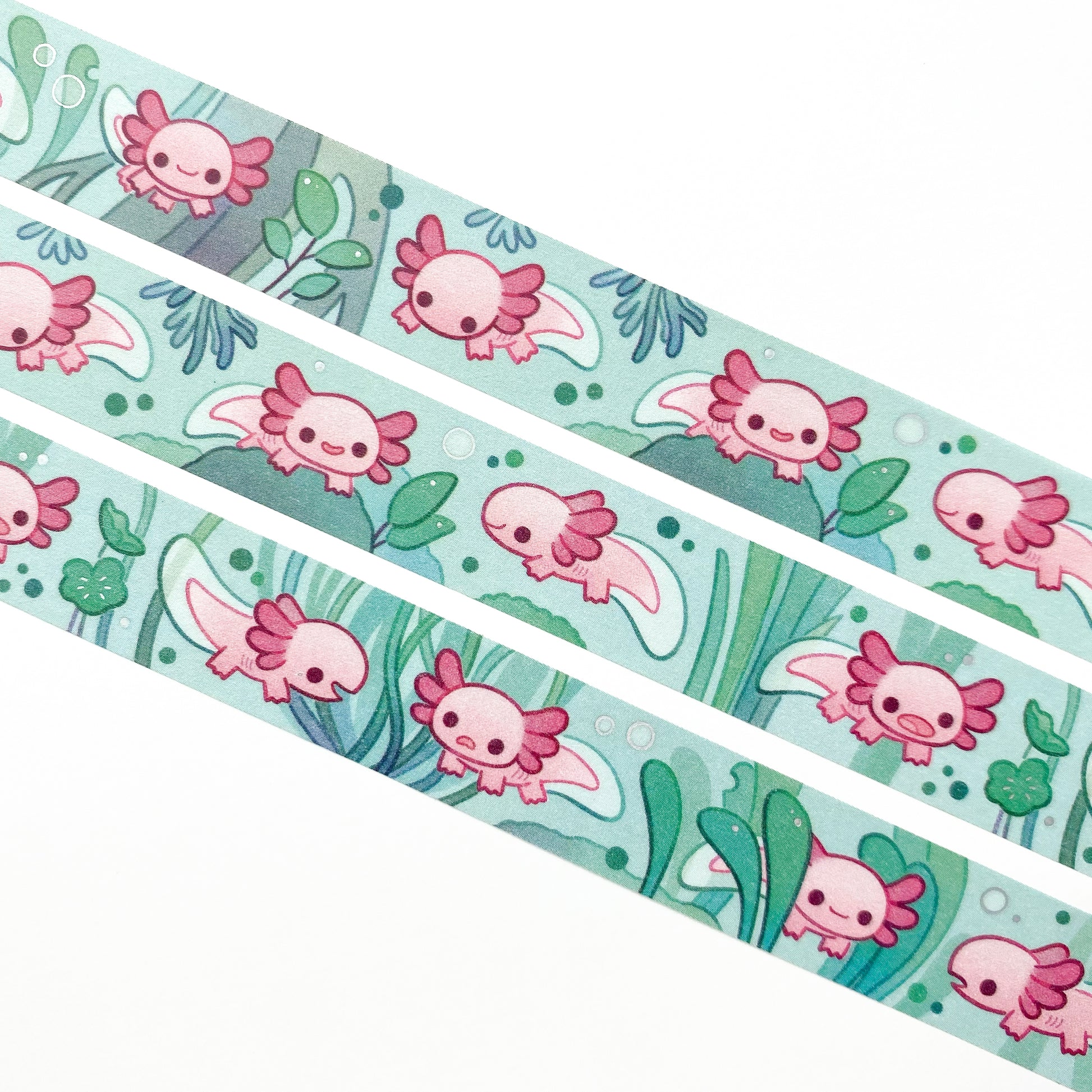 A close-up of the washi tape. The axolotls are swimming around among the roots, leaves, algae and other plants. 