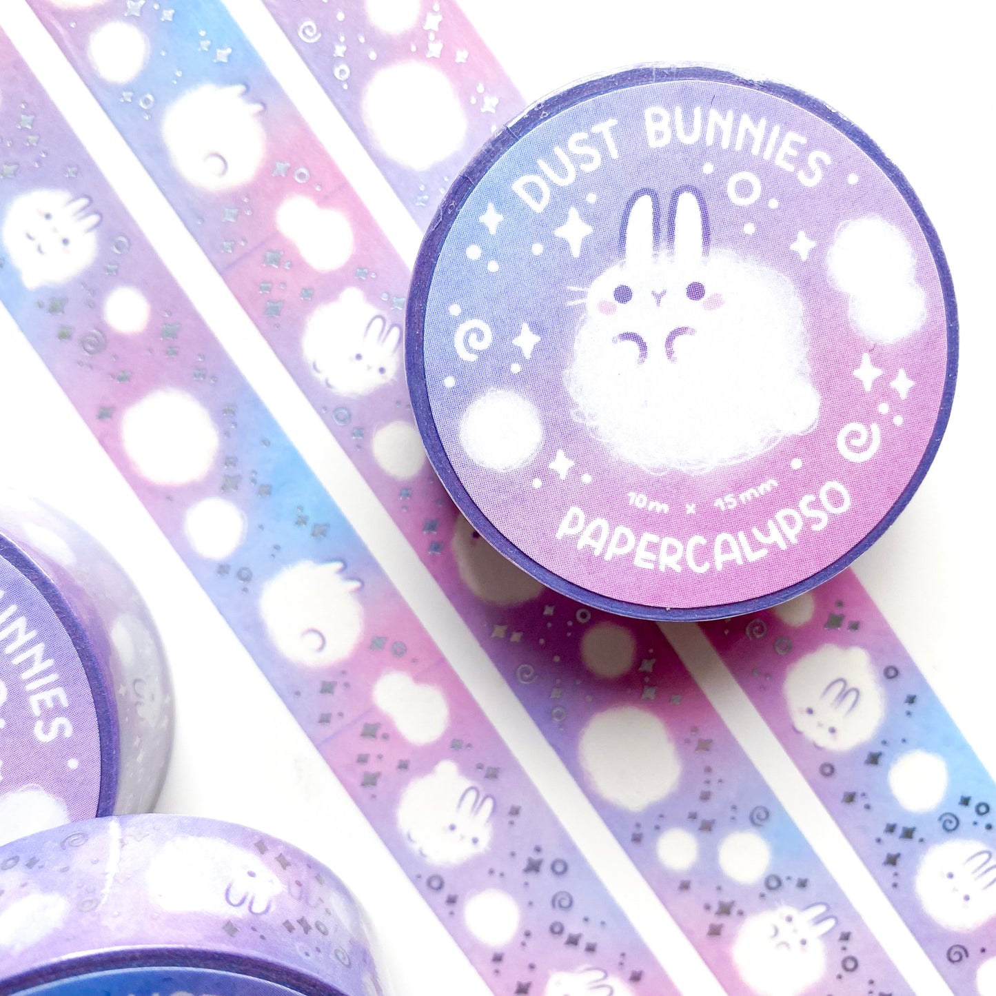 kawaii dust bunny themed washi tape featuring round, white cartoon rabbits on a pastel pink background. The bunnies are calmly floating around and enjoying their existence as little balls of dust.