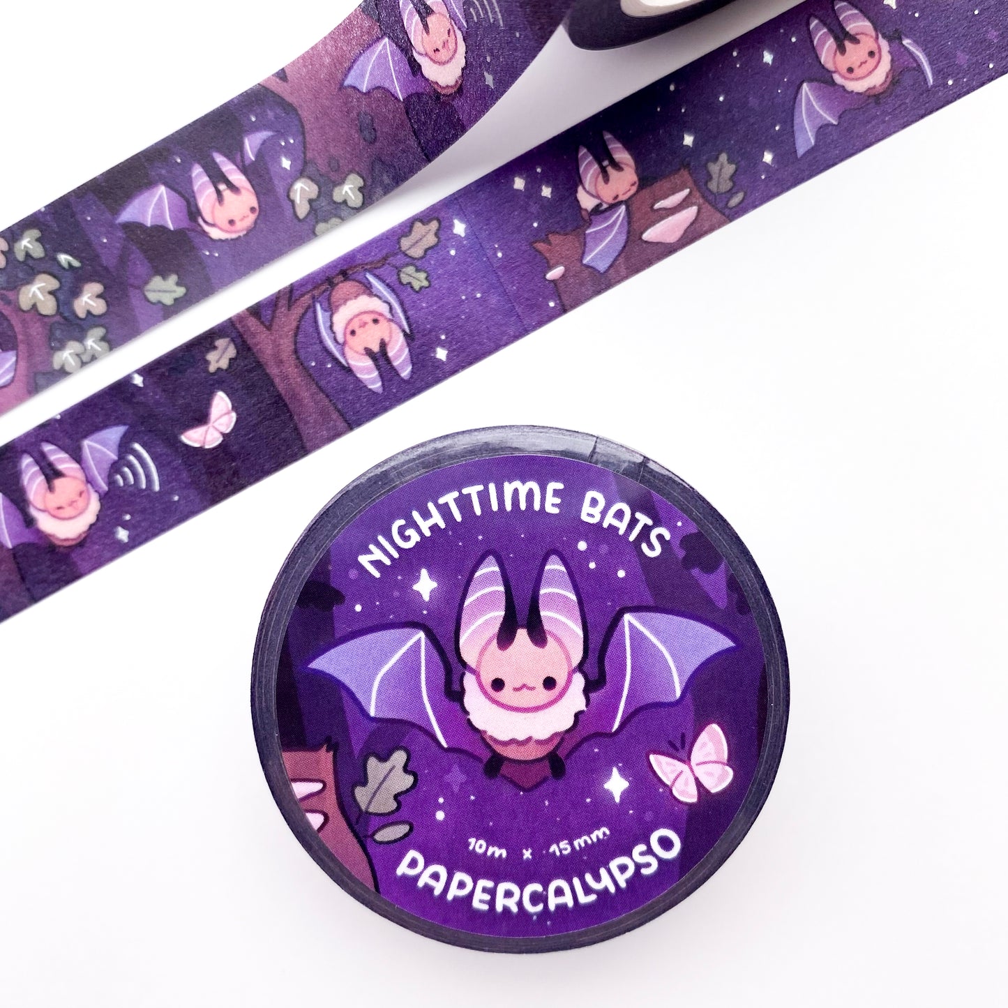 the roll of washi tape is packaged with shrink wrap plastic and a round sticker on one side. On it is a fluffy little bat with it's wings spread out. It reads "Nighttime Bats, 10 metres by 15 milimetres, by Papercalypso"